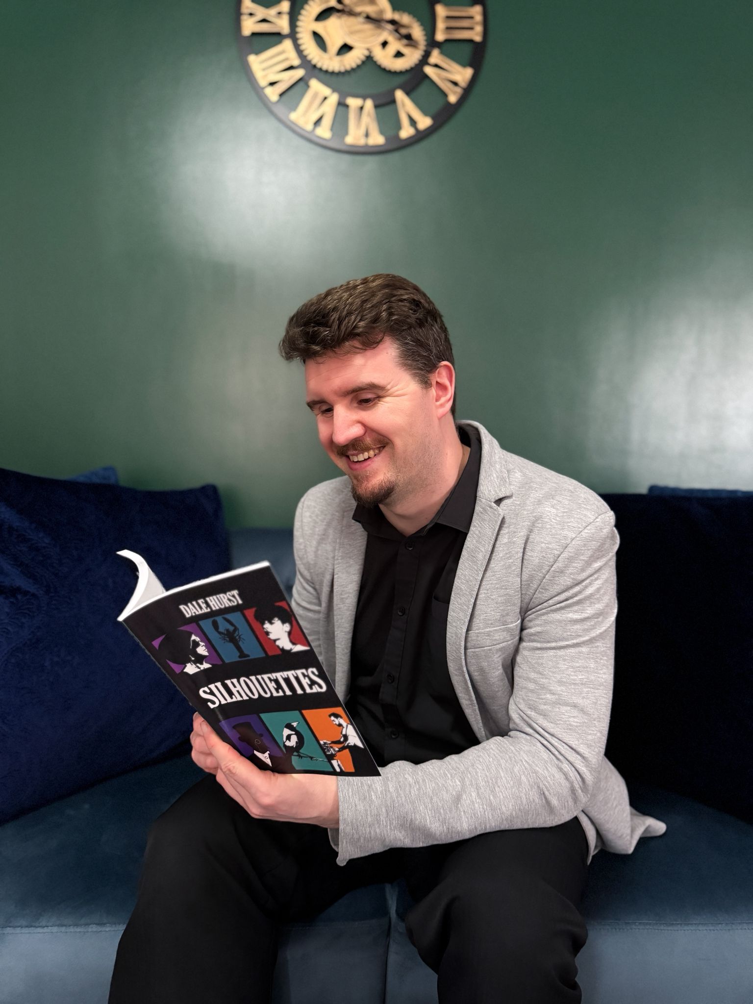 Dale Hurst sitting and reading a copy of "Silhouettes".